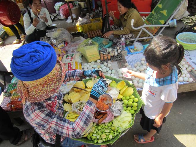 A boy makes the inevitable hard choice of a treat in the Battambang's wholesale food market.